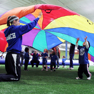 kids playing with parachute in lil' kickers cottontails class.