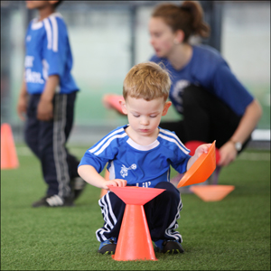 boy stacking cones in lil' kickers hoppers class.