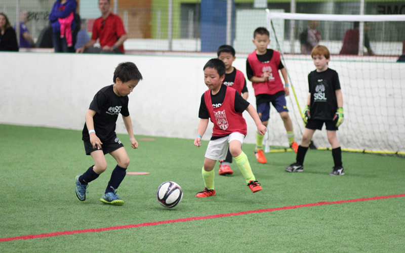 Skills Institute Soccer League boys playing at the goal