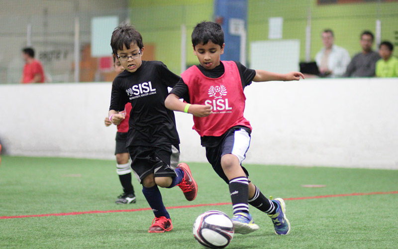 Skills Institute Soccer League boys kicking ball