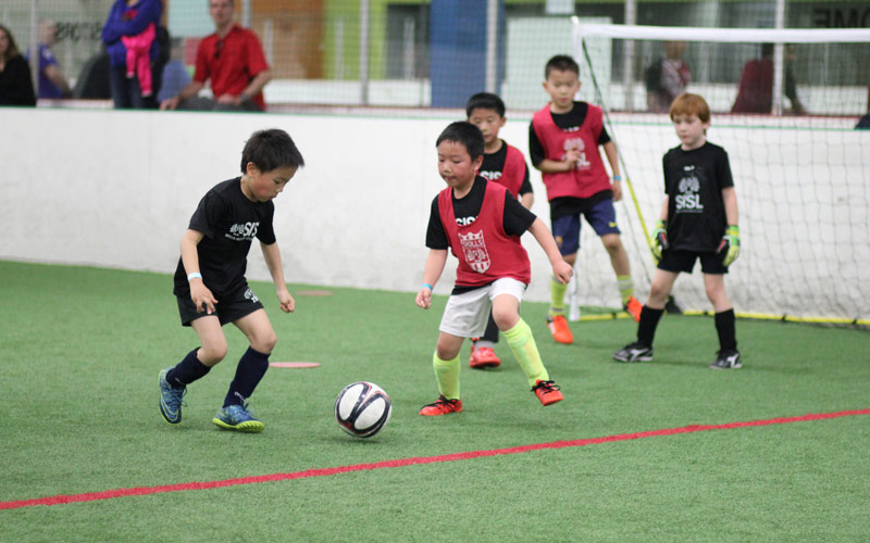 Skills Institute Soccer League boys playing at the goal