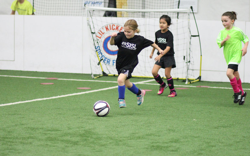 Skills Institute Soccer League girls kicking ball