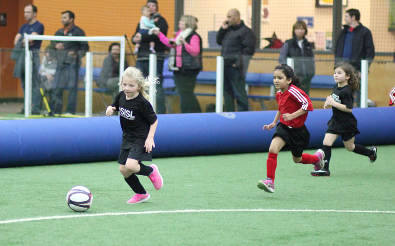 Skills Institute Soccer League game with girls running on field