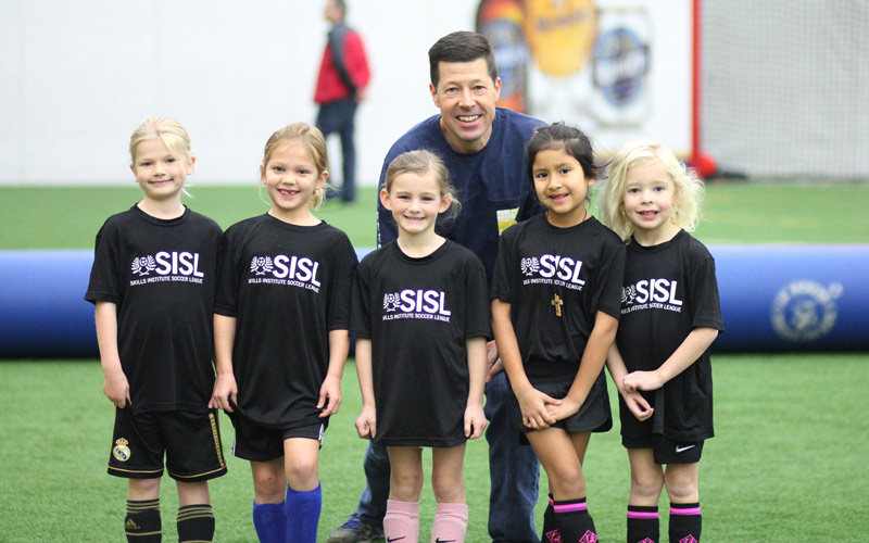 Skills Institute Soccer League girls smiling with coach