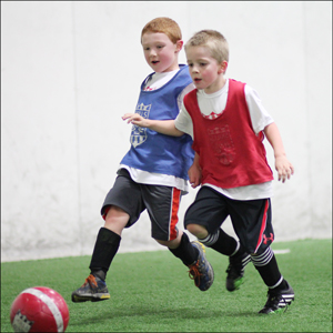 two kids playing in lil' kickers and skills institute class