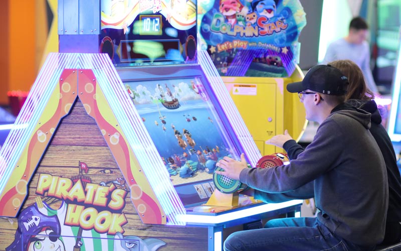 A man and woman play arcade games at Arena Sports Mill Creek