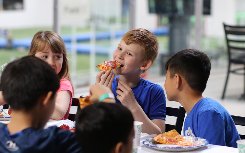 Boy Eating Pizza with Friends at Birthday Parties