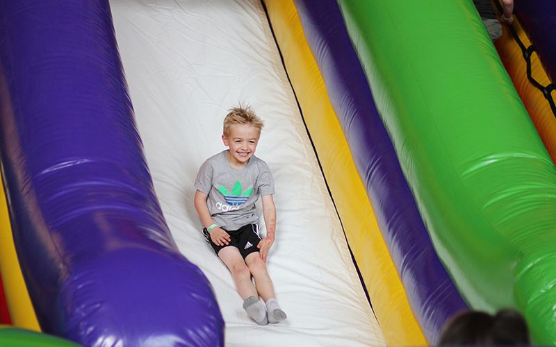 young boy sliding down inflatable slide