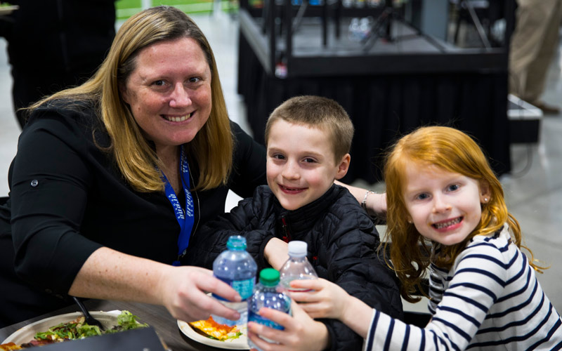 A family smiling during a corporate event at Arena Sports in Mill Creek