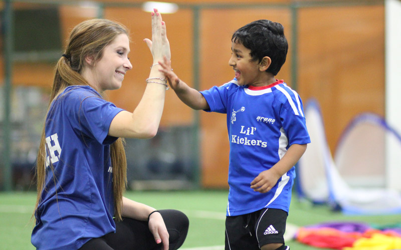 Employment opportunity coach and kid high-five