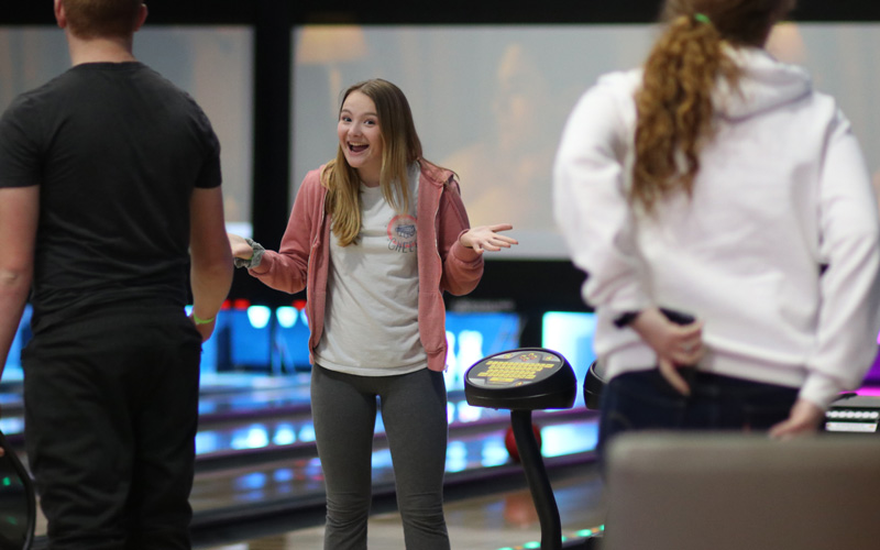 Teen smiling at group events bowling