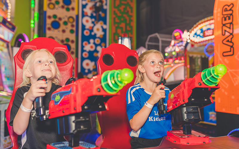 two young girls playing space invaders video game