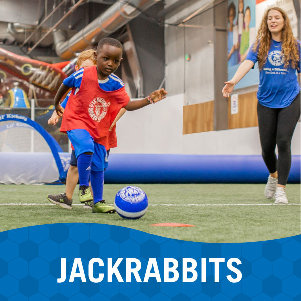 Child performs soccer drill with instructor in Lil' Kickers Jackrabbits class