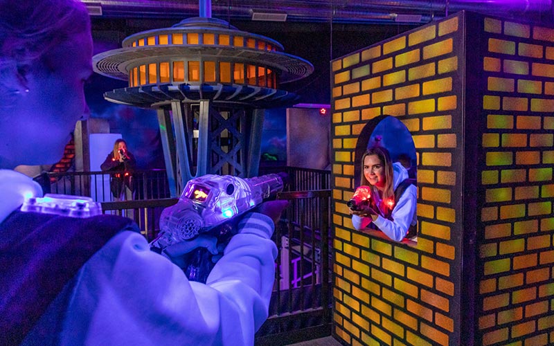 Two people play laser tag in the Family Entertainment Center at Arena Sports