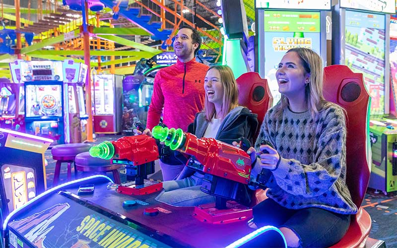 Two people play arcade games at Arena Sports Mill Creek