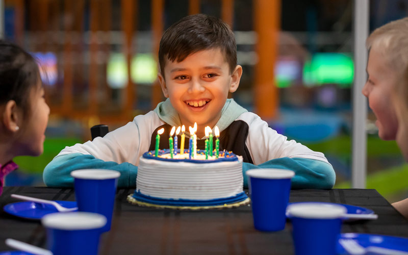 Birthday Boy Smiling with Cake and Lite Candles