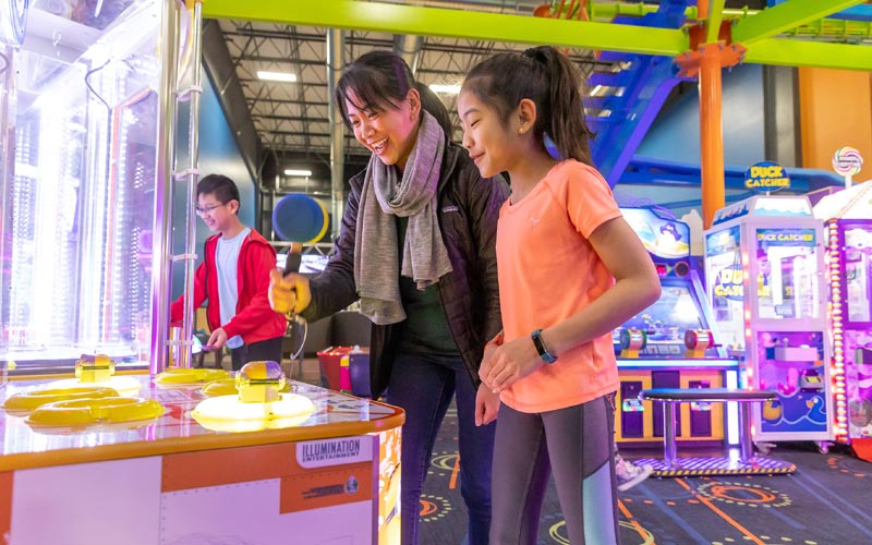 A mom and daughter play games at the Arcade at Arena Sports