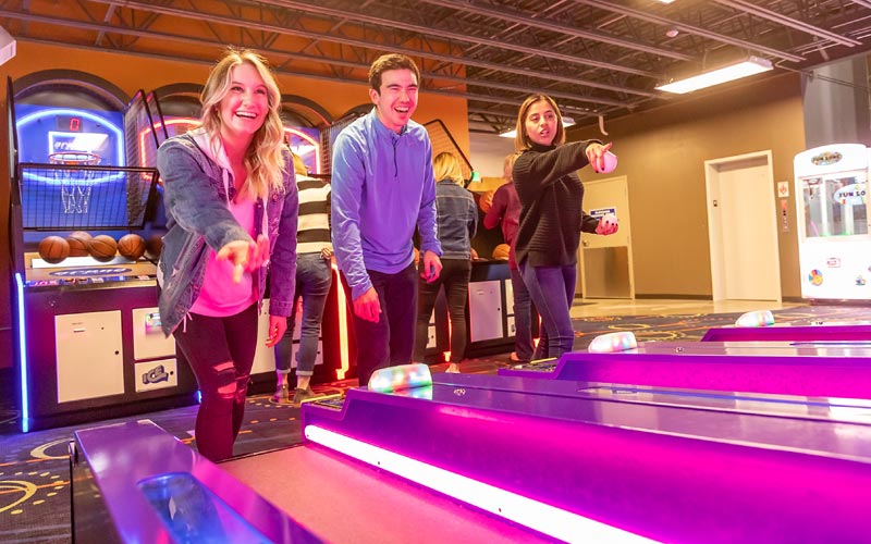 Young Adults Play Skee Ball