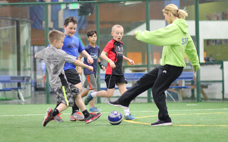 Kids play indoor soccer at a Field Games birthday party at Arena Sports