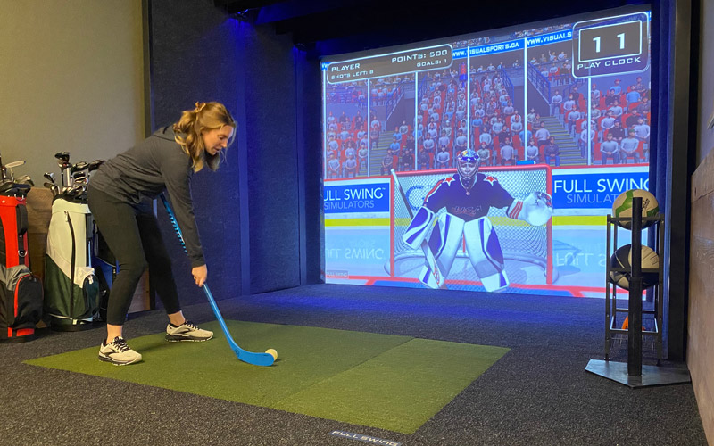 Woman Playing Hockey in Sports Simulator