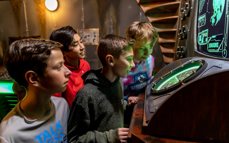 A group of kids try to solve the mystery in an escape room at the Family Entertainment Center at Arena Sports