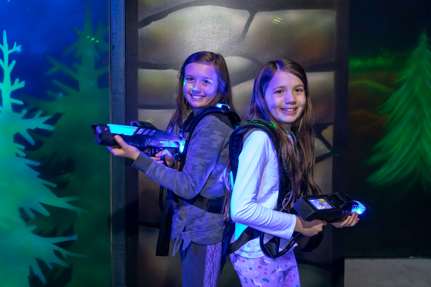 young sisters playing laser tag