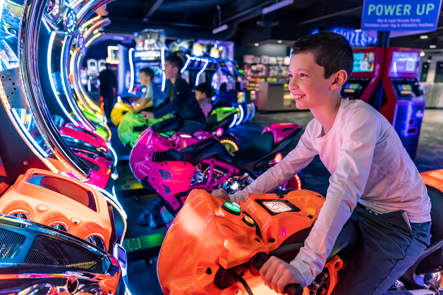Boy playing a motorcycle arcade game