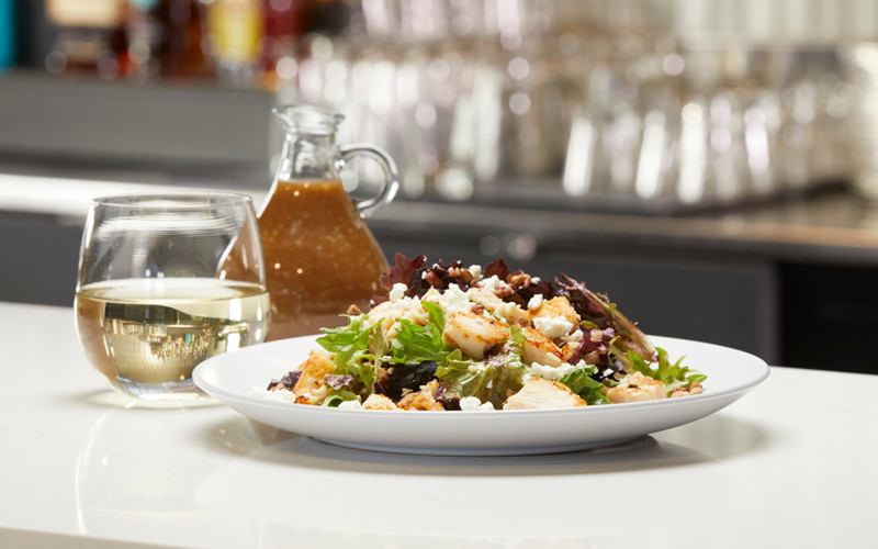 Maple salad with chicken and a glass of white wine