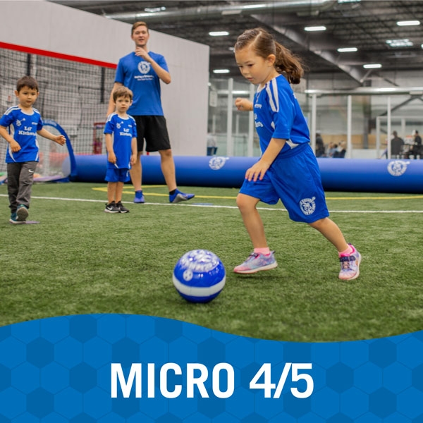 Child works through soccer play while other children and instructor watch in Lil' Kickers Micro 4/5 class