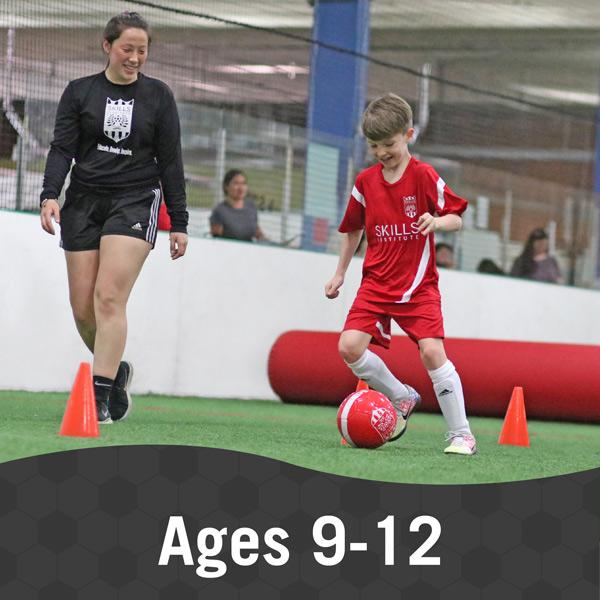 Boy and instructor work on a soccer play in Skills Institute 9-12 class