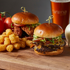 Two gourmet burgers served with tater tots and a beer at Arena Sports Restaurant