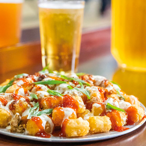 A plate of delicious amazing "tachos" and a cold beverage from the restaurant and bar at Arena Sports