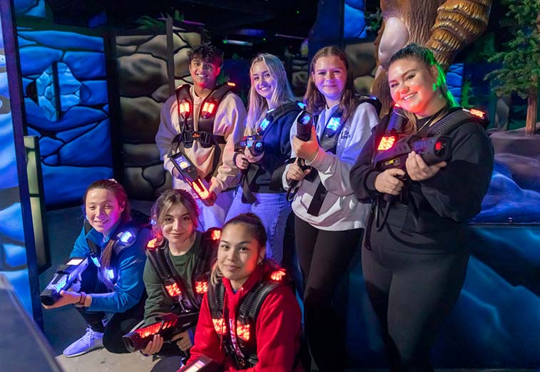 A group of people pose while playing Laser Tag during a group event at Arena Sports