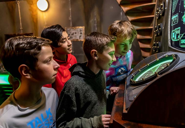 A group of boys try to find a clue in the Escape Room during a group event at Arena Sports