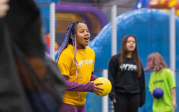 A young girl plays in a field game during summer camp at Arena Sports