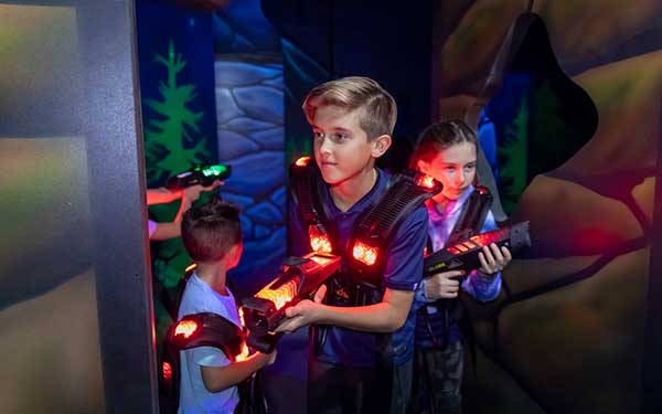 Young kids play in the laser tag arena during summer camp at Arena Sports