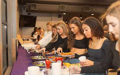 A line of teenagers at the buffet tables during a group event at Arena Sports