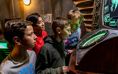A group of kids work on a puzzle in an Escape Room during a group event at Arena Sports