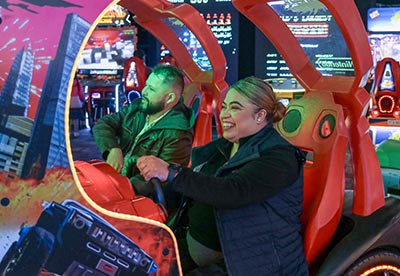 A man and woman play in an arcade game during a event at Arena Sports