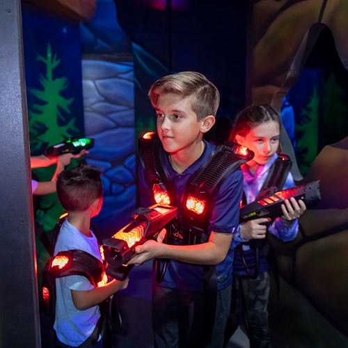 Three kids play laser tag at Arena Sports
