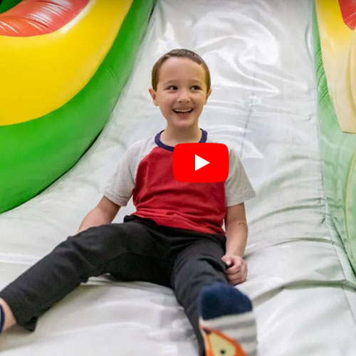 Video placeholder image of a boy sliding at the Inflatable Funzone at Arena Sports Mill Creek