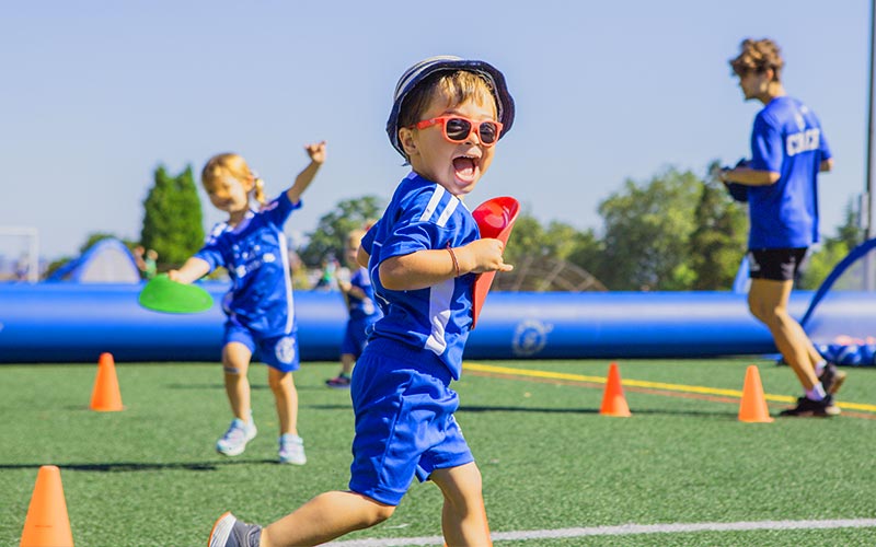 Young children merrily play during an outdoor field birthday party at Arena Sports