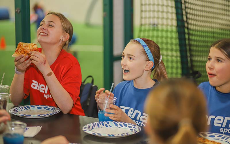 A group of young soccer league players celebrate the end of their season with a party at Arena Sports