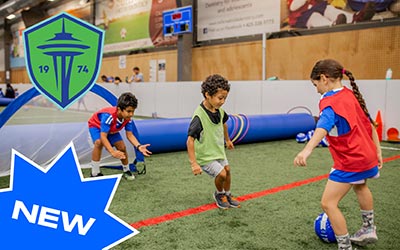 Kids play games on the indoor soccer field at Arena Sports during a Sounders FC field birthday party