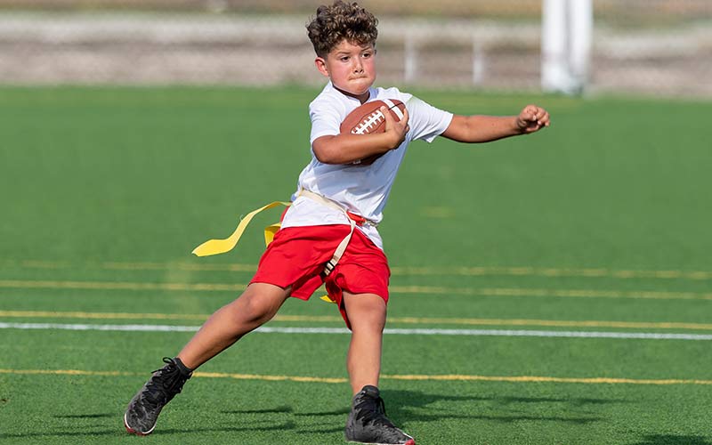 A child plays flag football during camp at Arena Sports