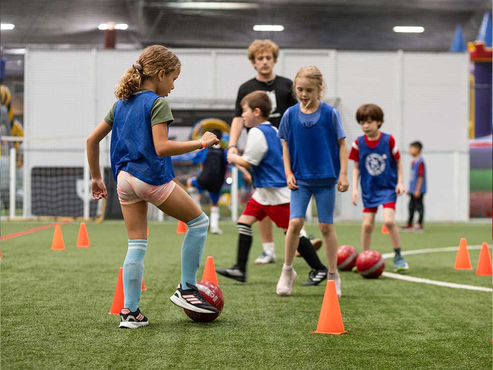 Girls and boys practice soccer drills during Skills Institute camp at Arena Sports