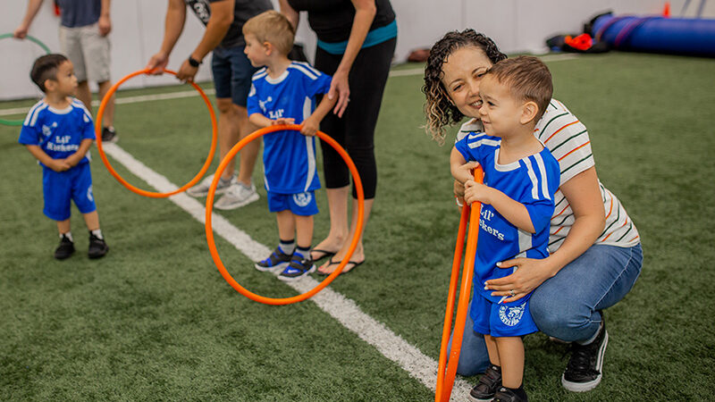 Young boy and mom playing during Lil' Kickers class at Arena Sports.