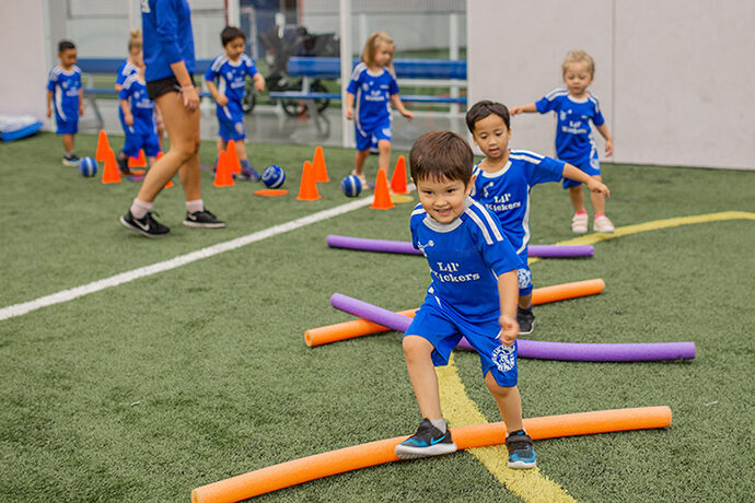 Kids playing during Lil' Kickers soccer class.
